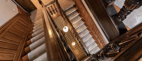 A grand staircase with wooden railings and a checkered carpet.