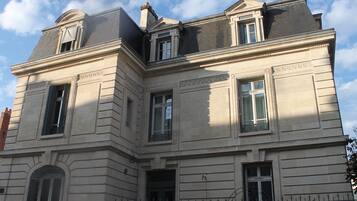 Un edificio histórico con fachada simétrica, múltiples ventanas y una entrada central destacada.