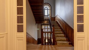 Un magnifique escalier avec des rampes en bois et une fenêtre à vitraux au sommet.