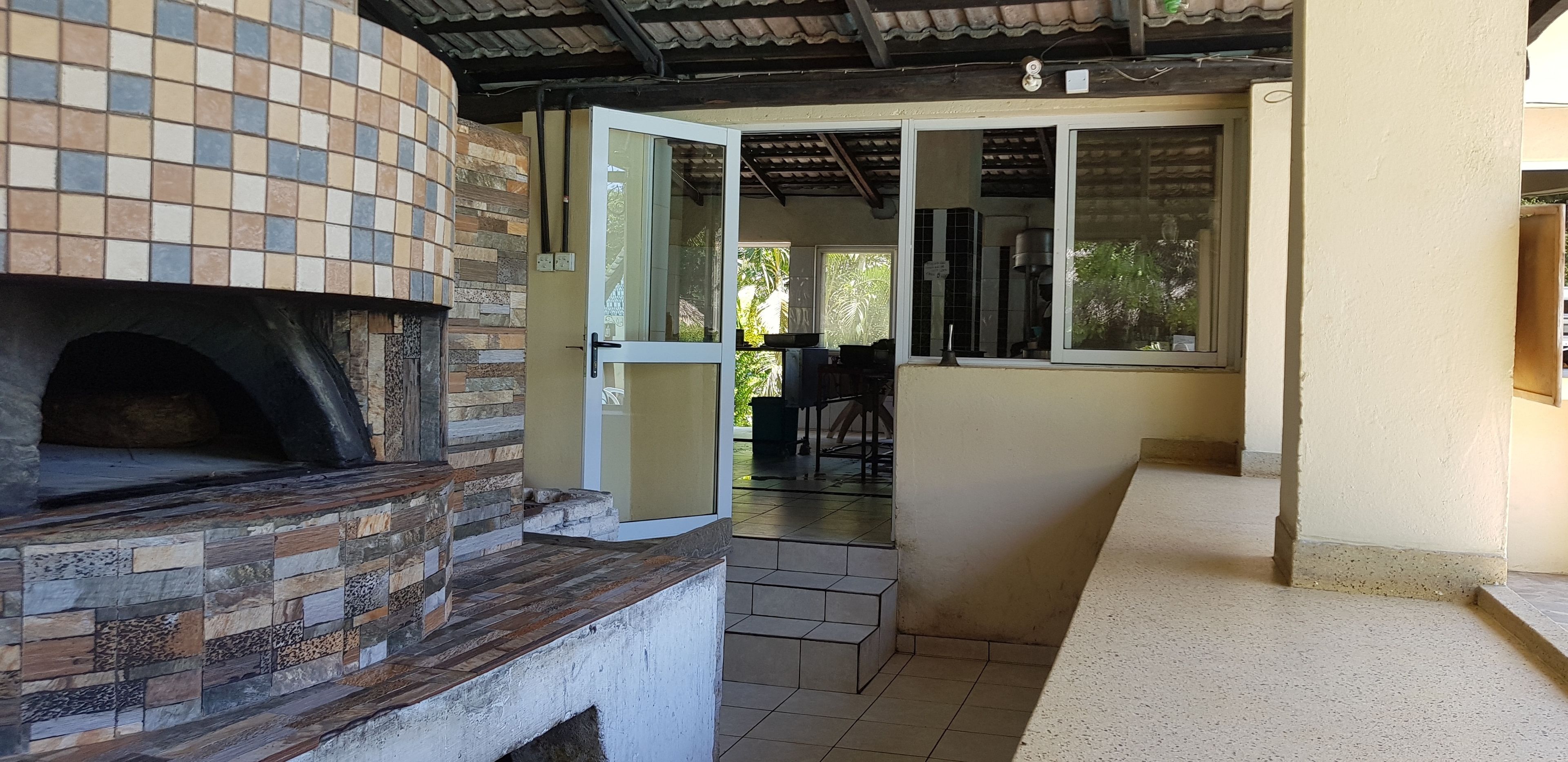 A kitchen with a tiled backsplash, a built-in oven, and a window overlooking a patio area.
