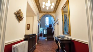 A hallway with a radiator, a staircase, and a mirror on the wall. - City Studios - Rodney Street (Liverpool)