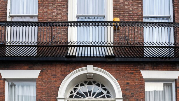 A brick building with a green door, white-framed windows, and a black metal railing. - City Studios - Rodney Street (Liverpool)