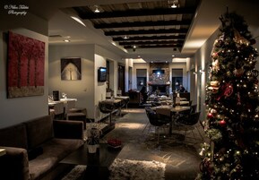 Una sala de estar acogedora y bien iluminada con chimenea, comedor y árbol de Navidad.