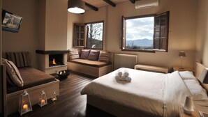 Un dormitorio acogedor con chimenea, un ventanal con vistas y una zona de estar confortable.