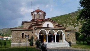 A stone church with a red-tiled roof, a bell tower, and a paved entrance. - Lydia Hotel (Kavala)