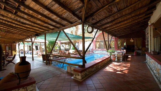 An indoor pool area with a wooden ceiling, stone walls, and a tiled floor. - Lydia Hotel (Kavala)