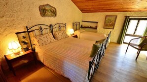 A cozy bedroom with a large bed, two bedside tables with lamps, a chair, and a wooden ceiling. - B&B Marie Thérèse (Torreano)