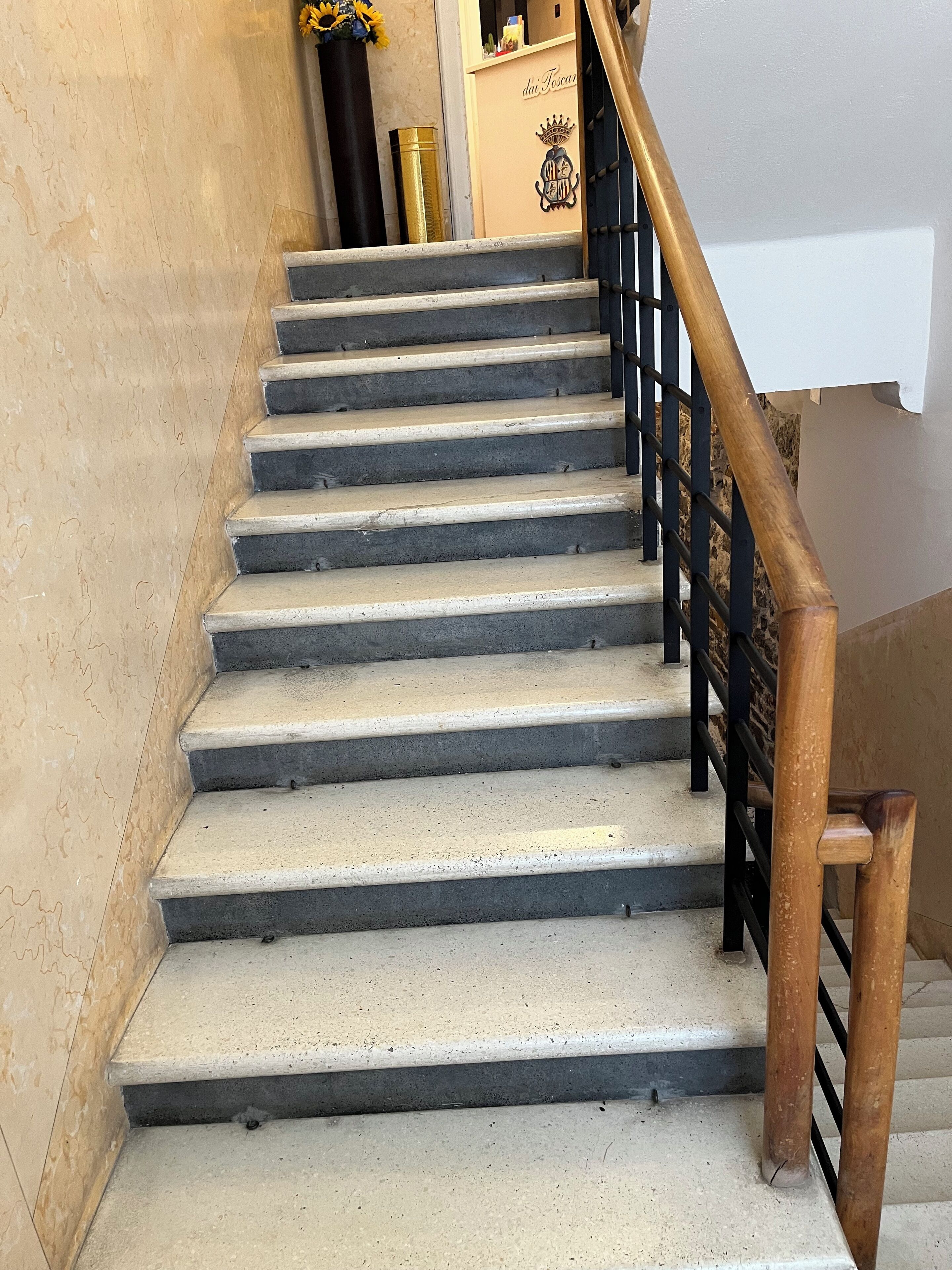 Una escalera con escalones de concreto y barandal de madera.