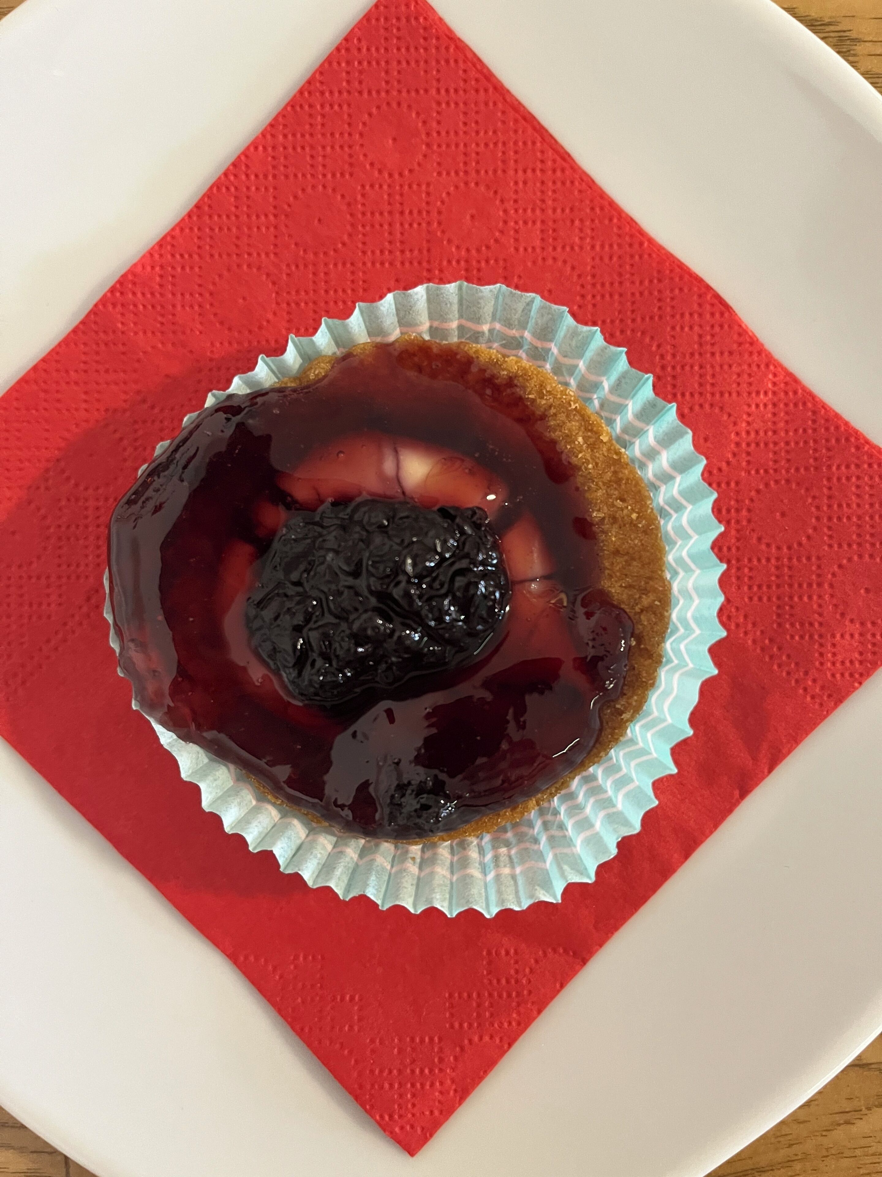 A dessert in a paper cup on a red napkin.
