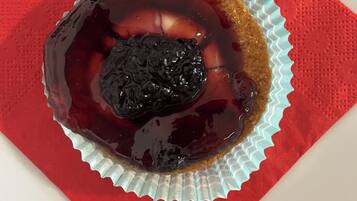 Un dessert in un bicchiere di carta su un tovagliolo rosso.