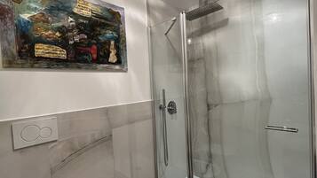 Une salle de bain moderne dotée d’une douche à parois de verre, d’un bidet et de toilettes.