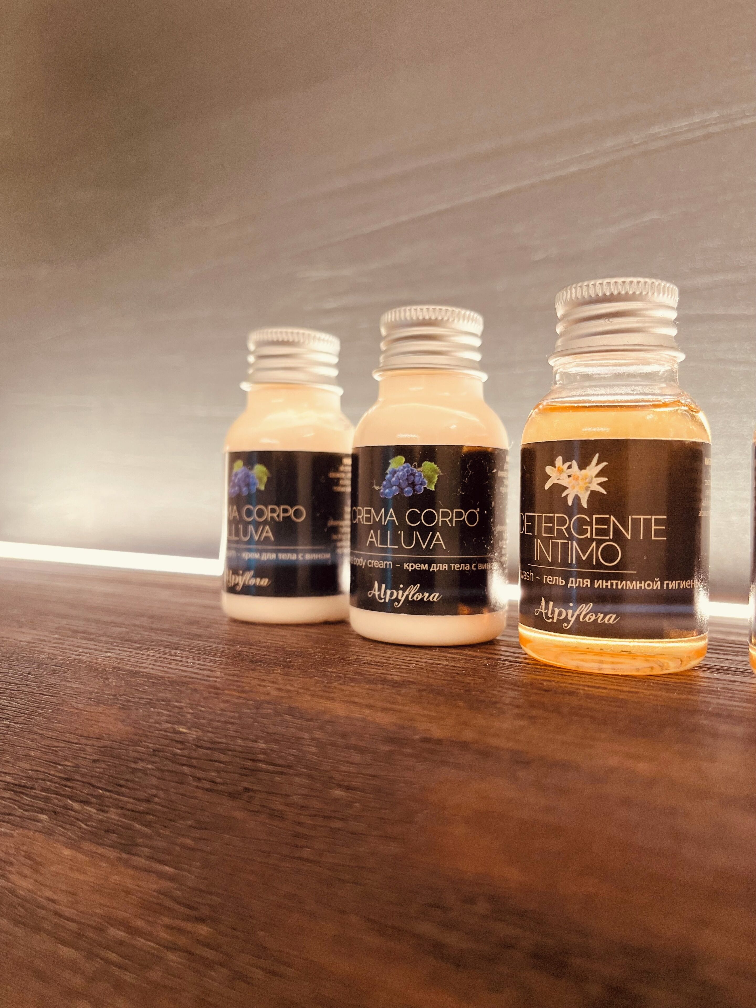 Trois flacons de crème pour le corps sur une surface en bois.