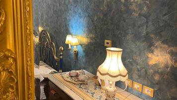 Een badkamer met een marmeren wastafel, een spiegel met gouden lijst en een blauwe, geruite wand.