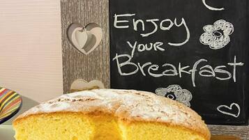 A slice of cake on a plate with a chalkboard in the background that says "Good Morning Enjoy your Breakfast."
