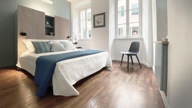 Une chambre à coucher comprenant un lit, une chaise, une fenêtre et une armoire intégrée.