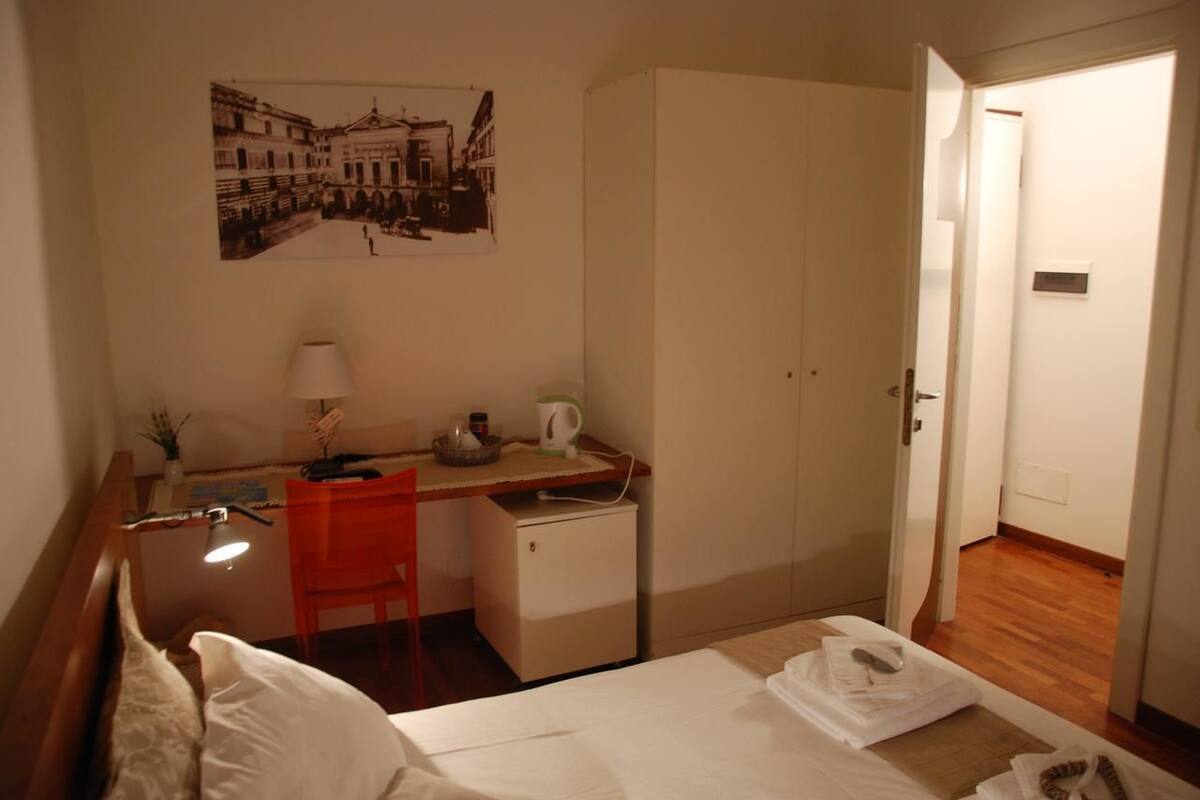 Ein Hotelzimmer mit Bett, Schreibtisch, Stuhl und einer kleinen Küchenzeile.