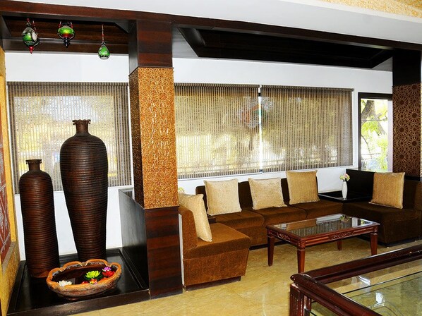 A living room with a sofa set, a coffee table, and decorative vases.
