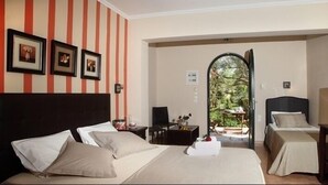A hotel room with two beds, a television, and a view of a garden through an open door. - Anthias Garden (Lefkada)