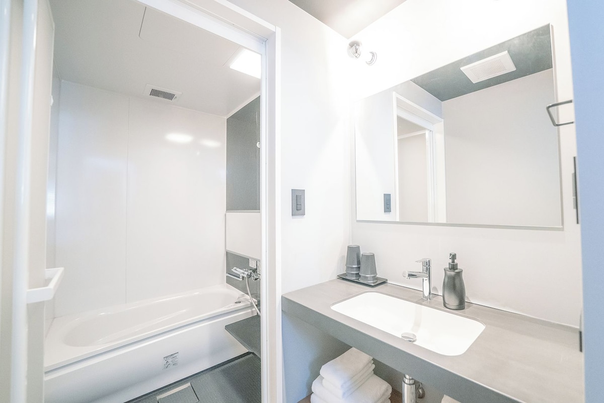 A modern bathroom with a bathtub, a sink, and a mirror.
