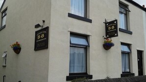 A building with two signs indicating overnight stays and accommodation services. - Overnight Stays Stockport (Stockport)
