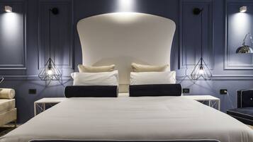 Una habitación de hotel moderna con una cama grande, dos mesitas de noche y una mesita auxiliar.