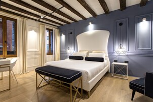 Camera da letto moderna con un letto grande, comodini, una panca e una scrivania.