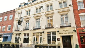 A hotel with a classic facade, featuring a sign for a function room and a cafe-bar restaurant. - The New County Hotel (Gloucester)