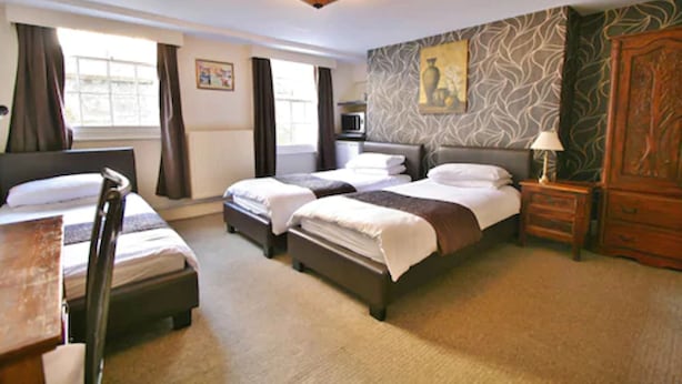 Une chambre d’hôtel avec deux lits, une télévision, un bureau et une armoire.