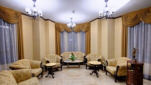 Un salón formal con un conjunto de sofá, una mesa de centro y una mesita auxiliar.