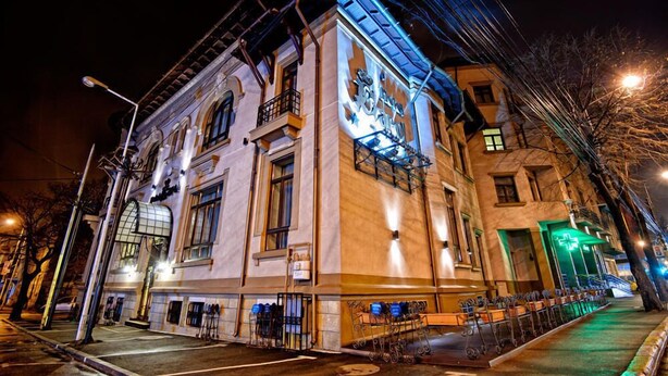 Un edificio histórico con una entrada destacada, ventanas amplias y un balcón.