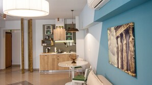 Una cocina moderna con una mesa redonda para comer, un sofá y un cuadro grande en la pared.