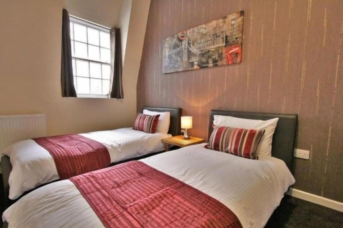 Habitación Deluxe con 2 camas individuales | Escritorio, tabla de planchar con plancha, wifi gratis y ropa de cama 