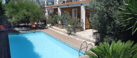 Piscine extérieure, parasols de plage, chaises longues