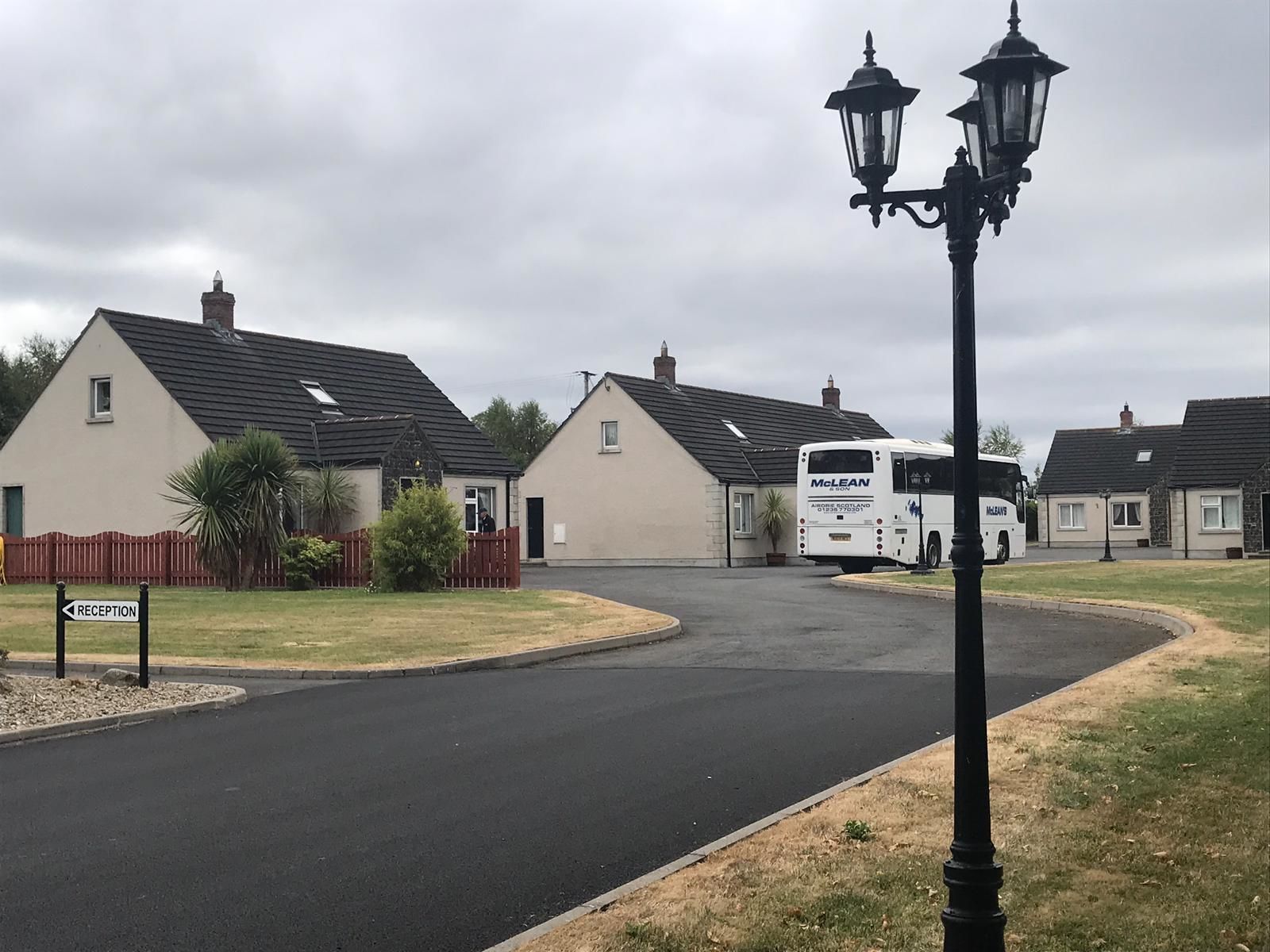 A residential area with houses, a reception sign, and a McLean bus.