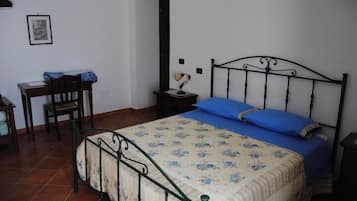 A bedroom with a bed, a desk, and a chair.
