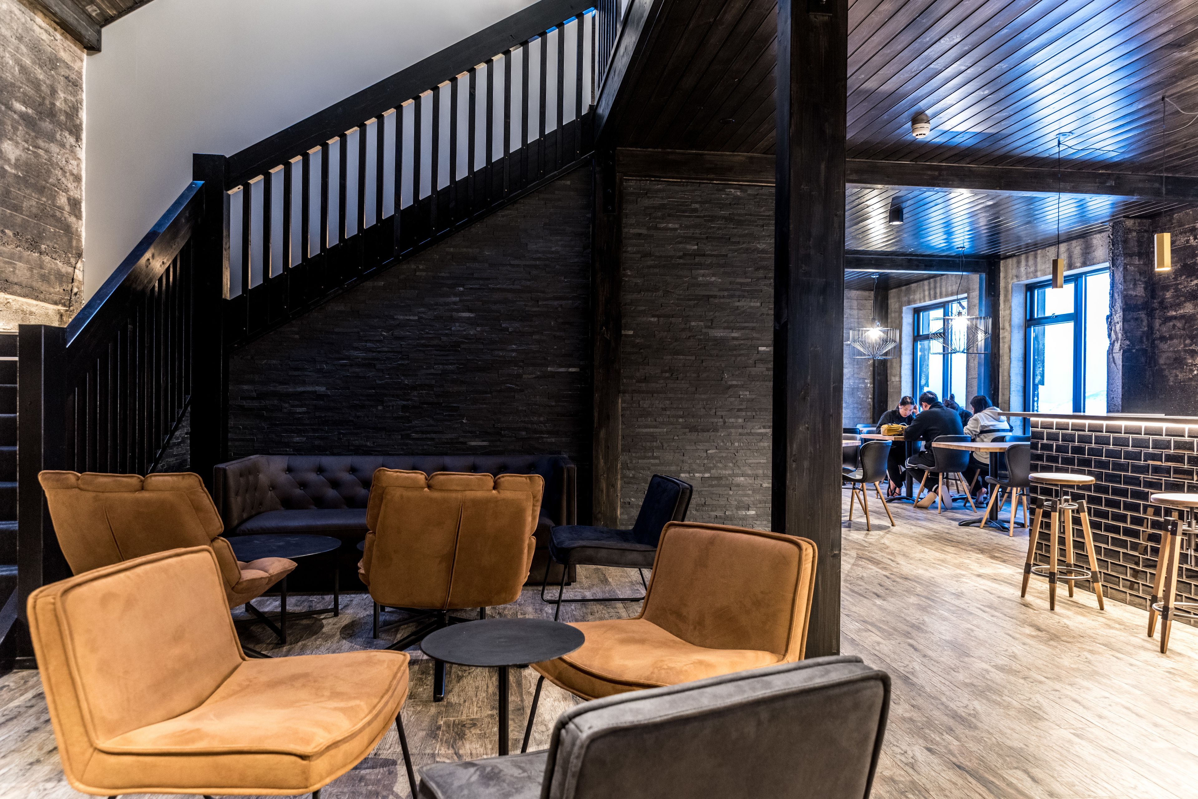 A modern interior with a staircase, leather seating, and a bar area.