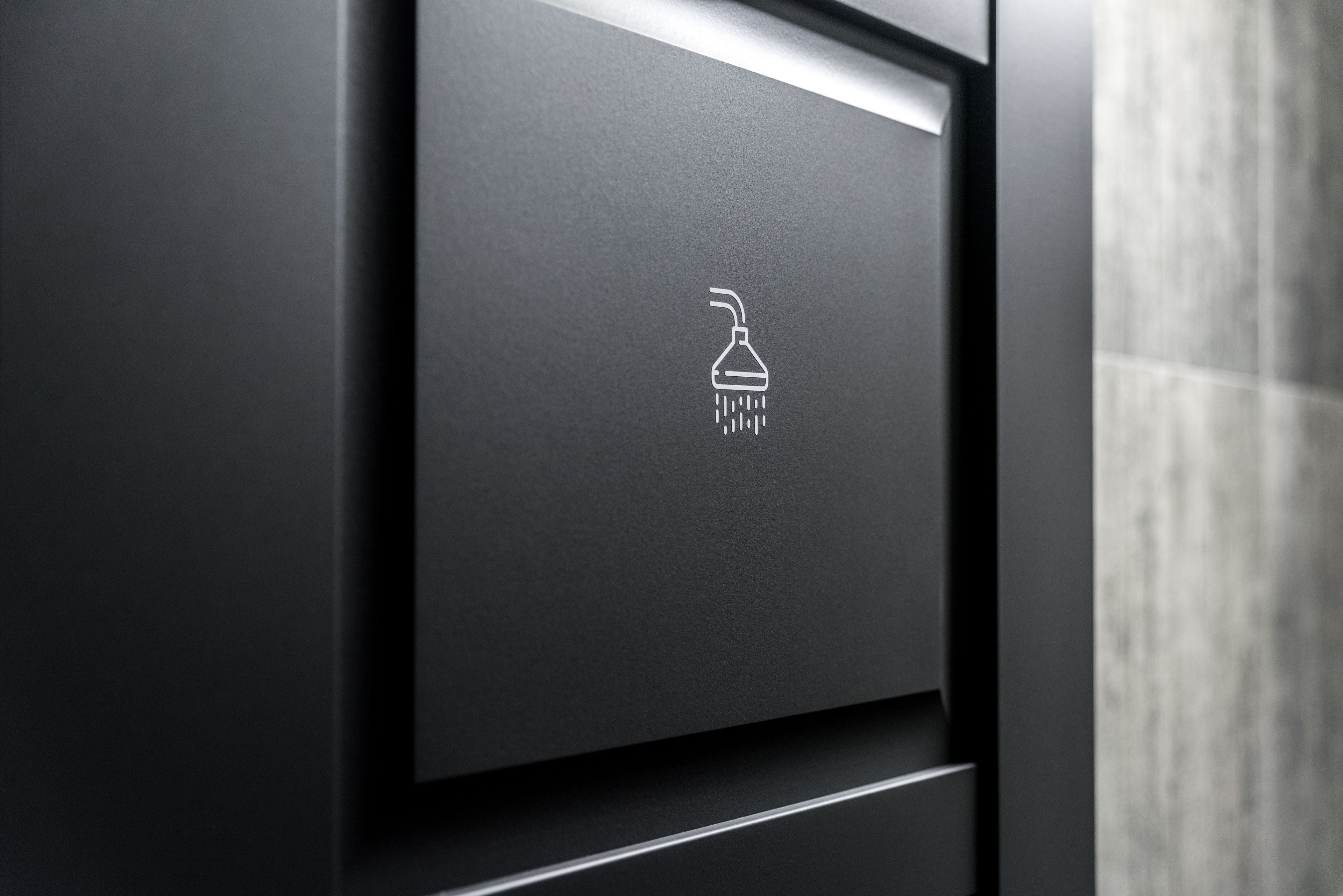 A bathroom with a shower icon on the wall.