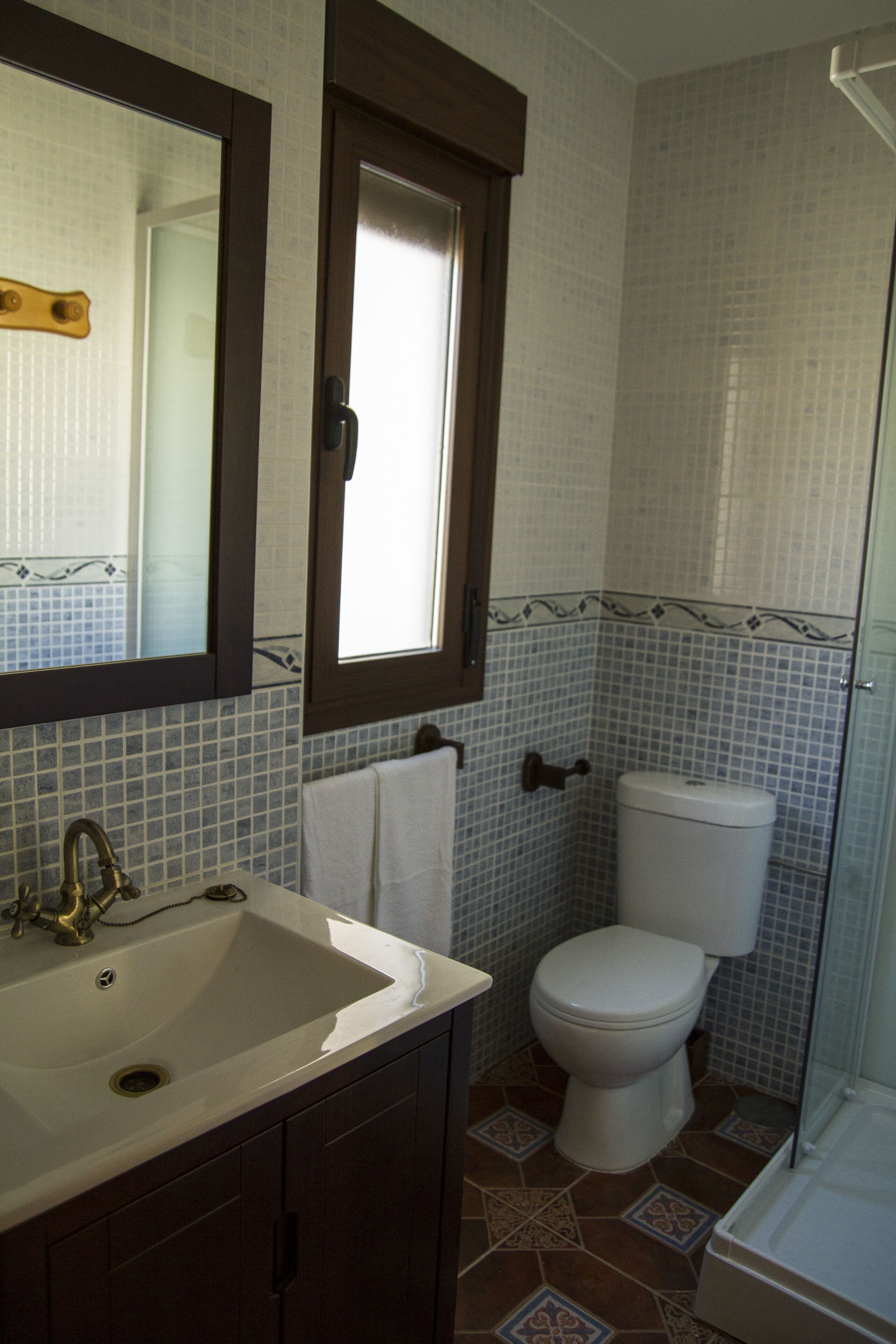 A bathroom with a sink, toilet, and shower.