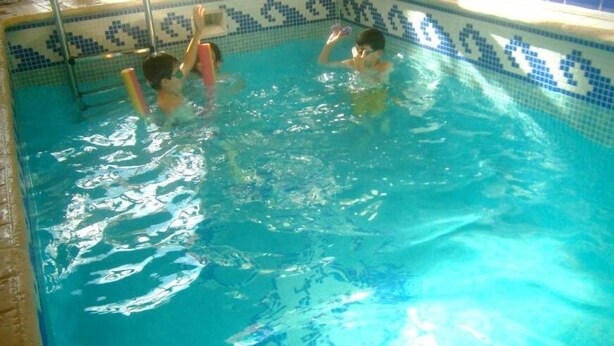 A swimming pool with clear blue water and a tiled border. - El Horno de Leopoldo (Hueva)