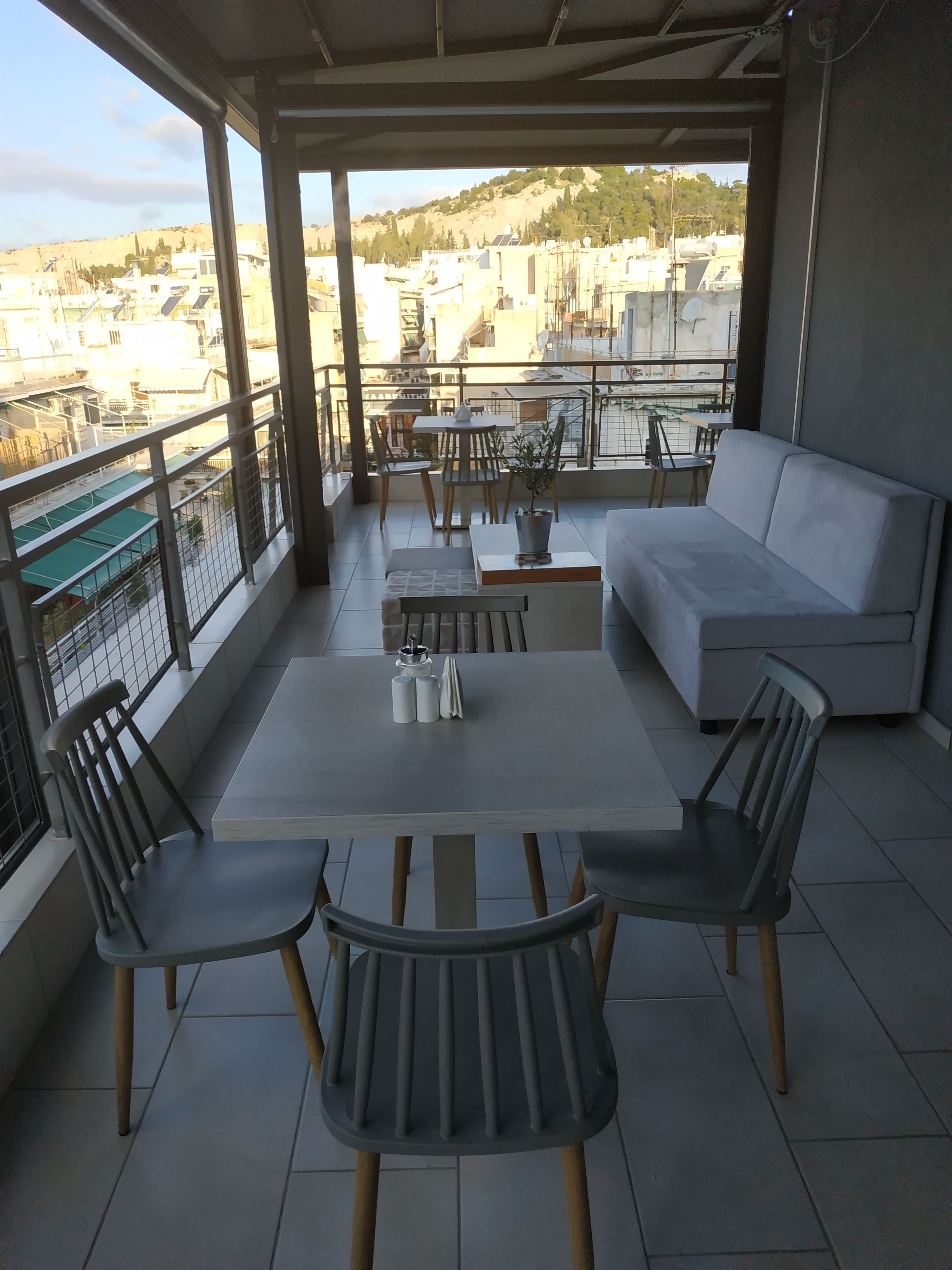 Un balcon avec une table, des chaises et un canapé.