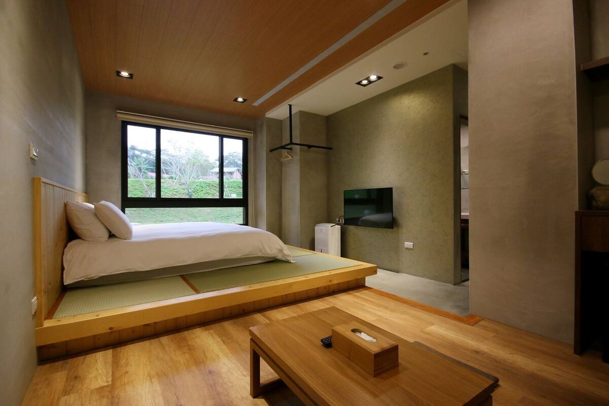 A room with a bed, a TV, and a wooden table.