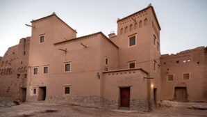 Il s’agit d’un bâtiment traditionnel à plusieurs étages, caractérisé par un mélange de fenêtres rectangulaires et carrées, et doté d’une entrée centrale bien visible.