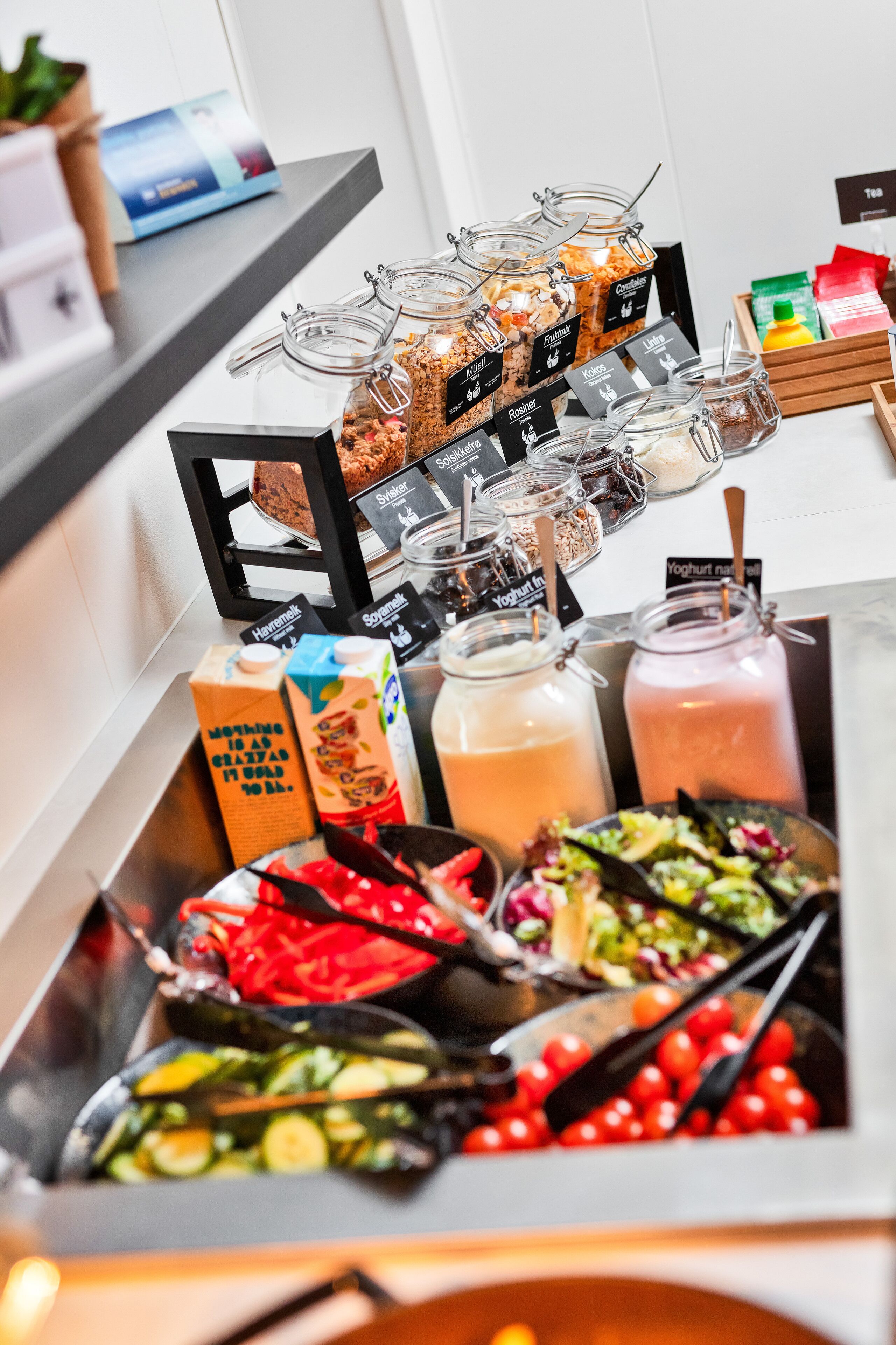 Un bufé con diversas opciones de comida, como ensaladas, frutas y bebidas.