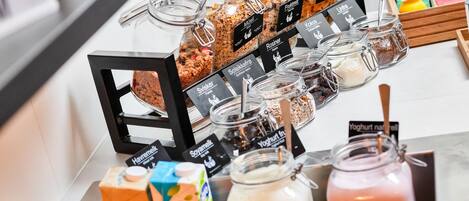 Un bufé con diversas opciones de comida, como ensaladas, frutas y bebidas.