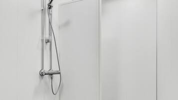 A modern shower with a handheld showerhead and a wall-mounted faucet.