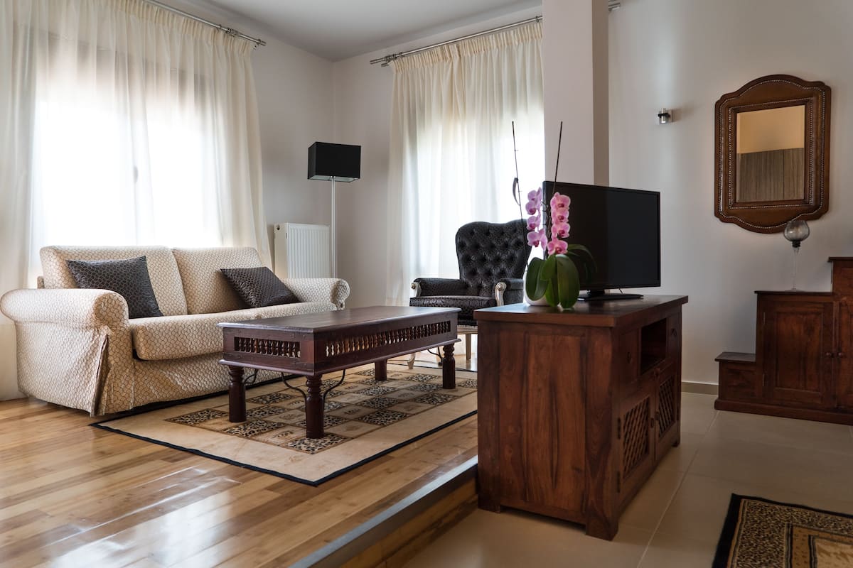 A living room with a sofa, a coffee table, a TV, and a wooden cabinet.