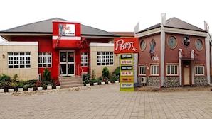 Un edificio con fachada roja y color crema, que muestra un cartel de 'Phia 4' y una lista de servicios que incluye club, comida rápida, bar, piscina y restaurante.