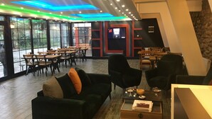 Um interior moderno com área de jantar, sofás e uma tela de televisão.