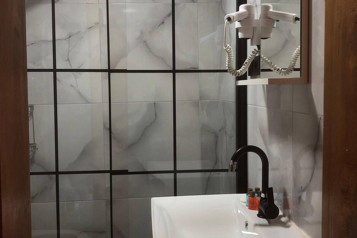 Un baño con ducha, inodoro y lavamanos.