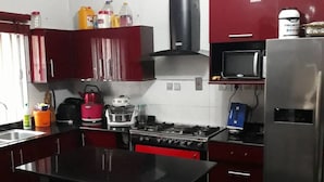 Una cocina compacta con una isla central, estufa, microondas y refrigerador.